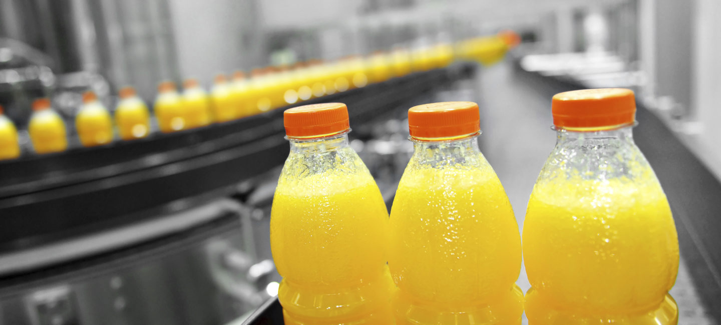 Bottles of orange juice on a production line to promote Spirax Sarco clean steam capabilities