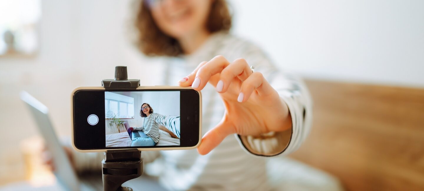 Young woman looking into the camera and telling her story while recording a video blog.