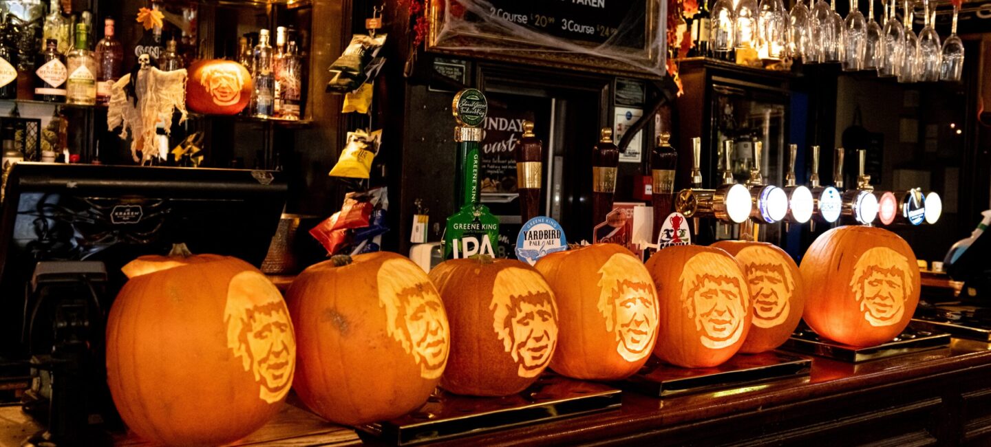 A row of Halloween pumpkin lanterns carved with Boris Johnson's face