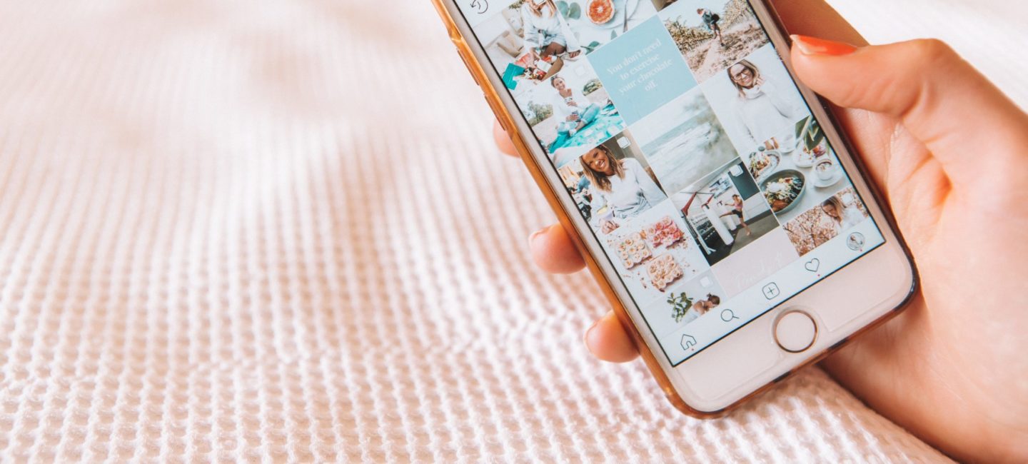 hand holding phone showing instagram grid