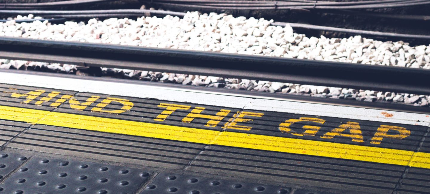 A Mind the Track sign on the edge of a train platform