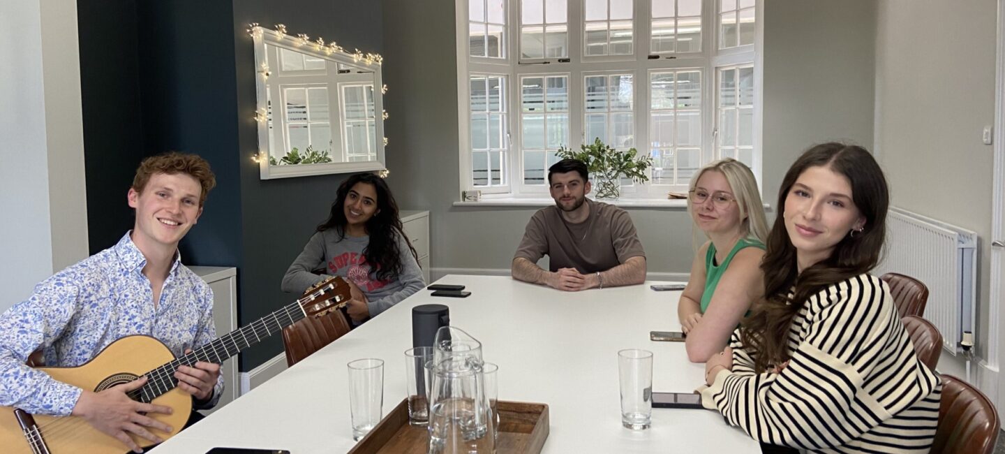 Members of the WPR team sitting around the boardroom table for a mindfulness through music session