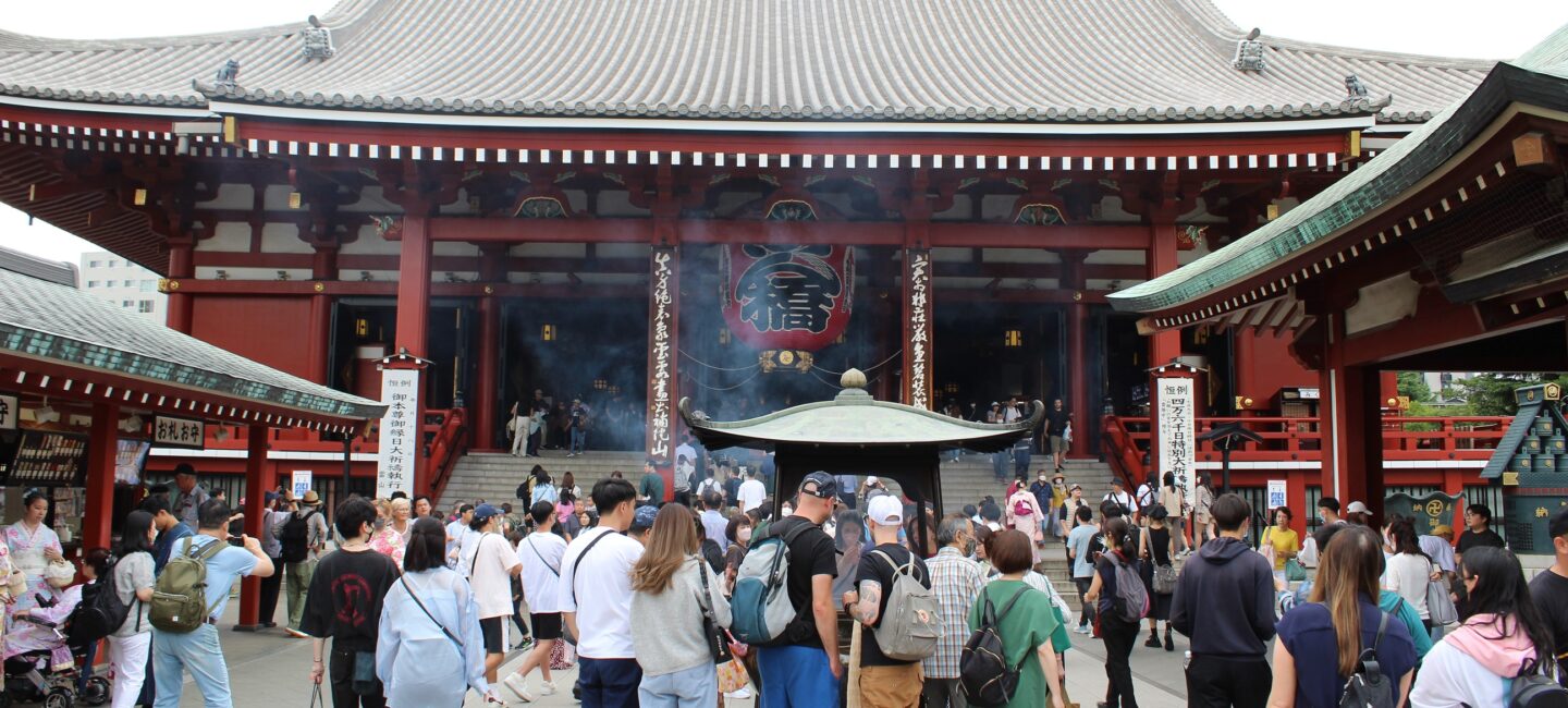 Japanese temple with tourists walking in front