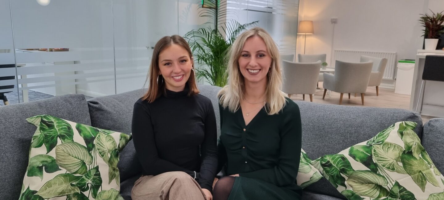 Ellen and Claire sitting on a sofa in the WPR office