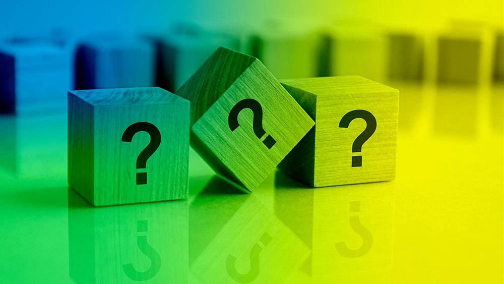 Three building blocks in a row with question marks printed on them