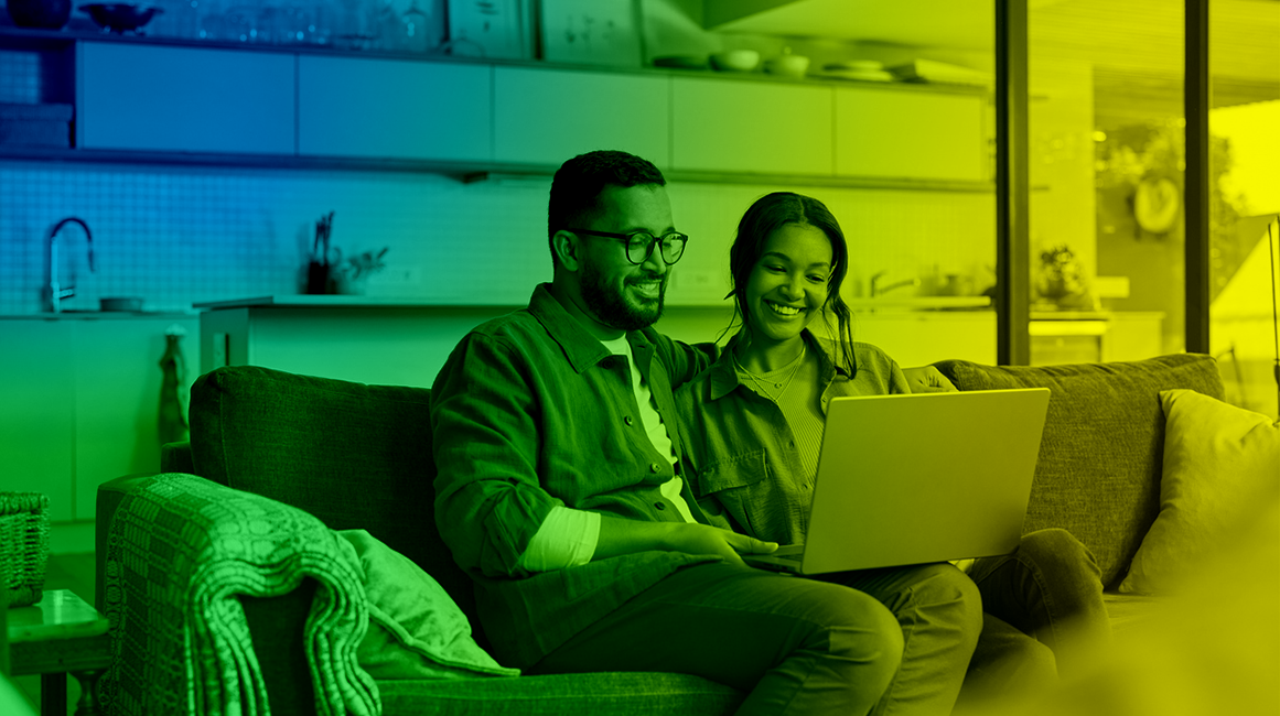 Man and woman sitting on sofa and browsing online