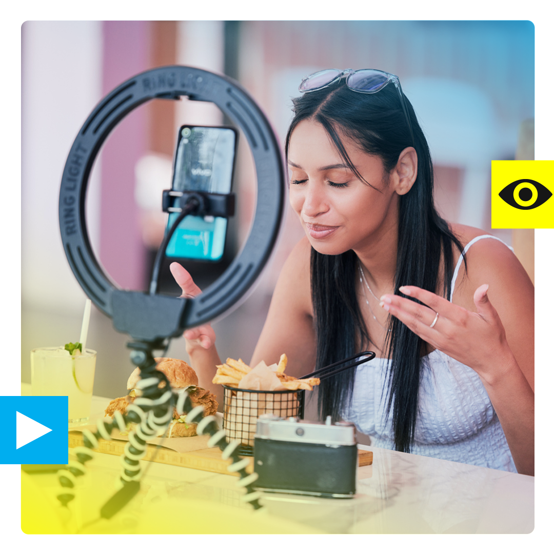 A woman looking at her plate of food while filming herself on an iphone